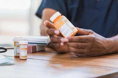 Hands holding a medicine bottle.