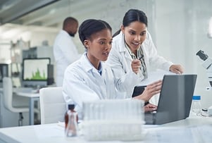 Two women technicians using a laptop in a laboratory.