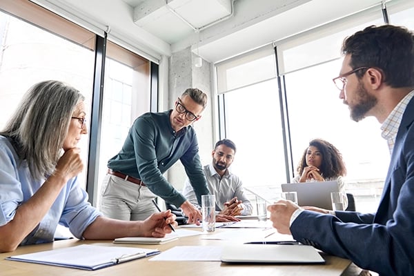 Professionals at a hands on meeting around a conference table