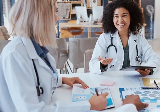 Two healthcare professionals talking at a table