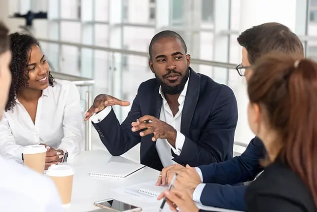 People smiling and conversing around a table