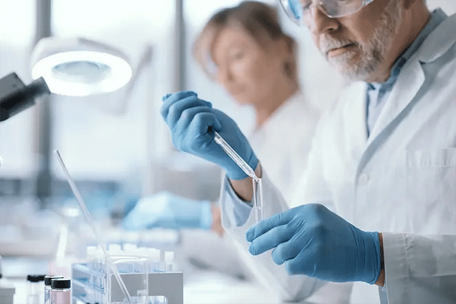 Laboratory technician using dropper with a test tube