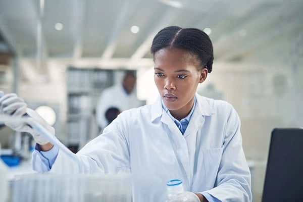 Lab tech injecting material into test tubes