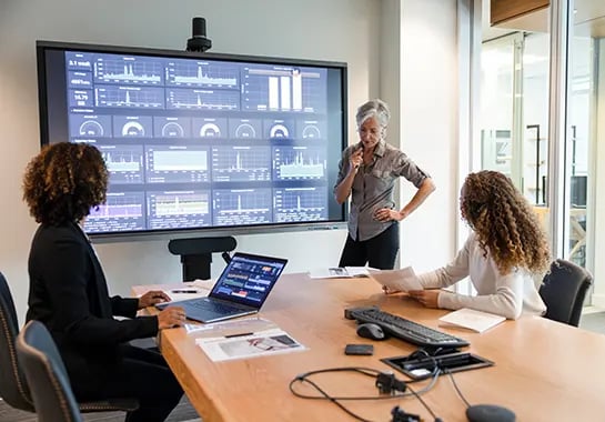 Conference room strategy meeting with charts, graphs, and advanced technology