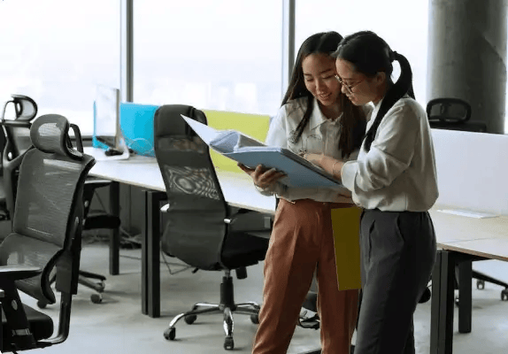 Women collaborating and looking at blueprints