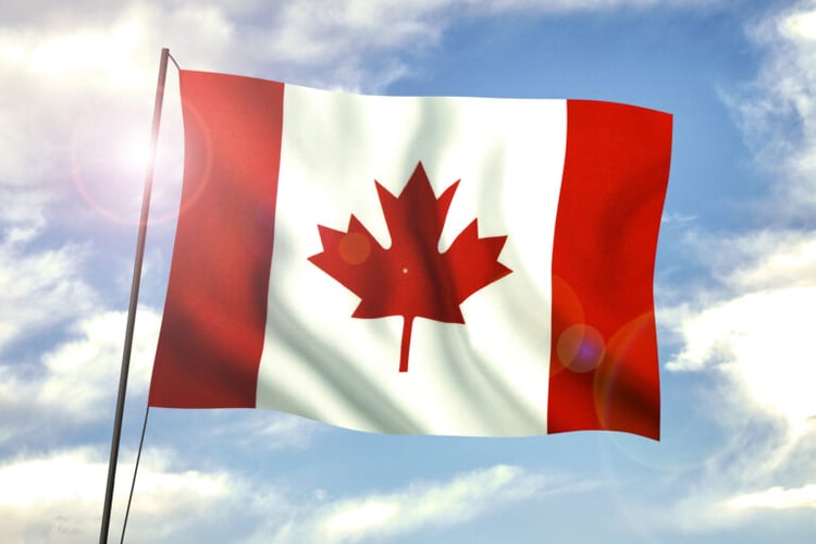 Canadian flag flying on flagpole.