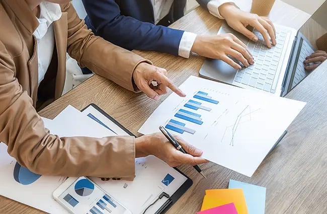 Business professionals working with charts and graphs at a table