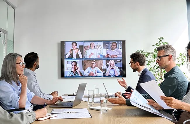 Business worker with virtual attendees in conference room