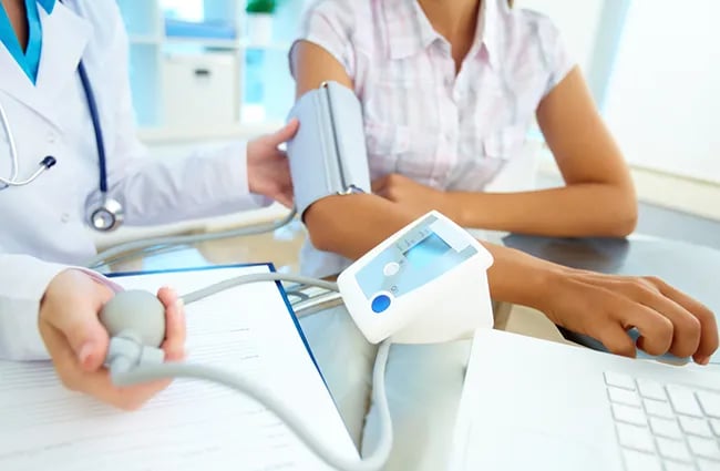 healthcare-provider-using-blood-pressure-cuff-on-patient-ss-110196416-650x425