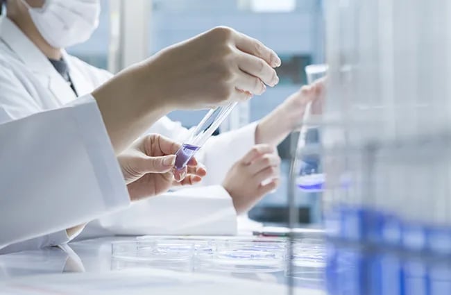 Person holding test tube with fluid