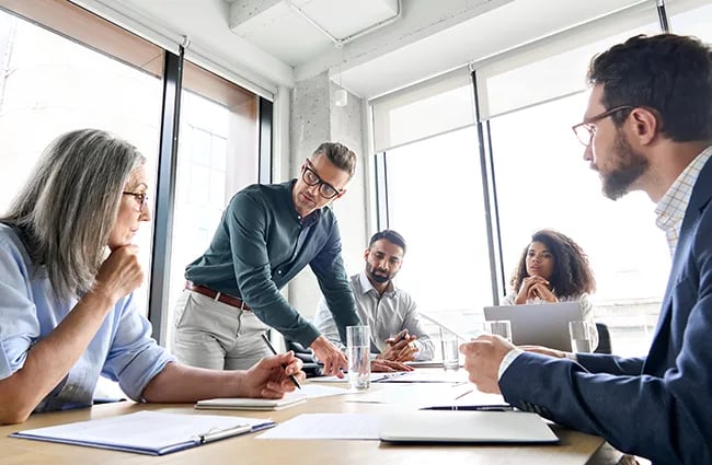 Several business professionals working around a conference table 