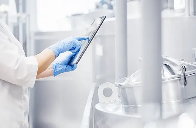 Lab tech using a tablet device in a manufacturing facility