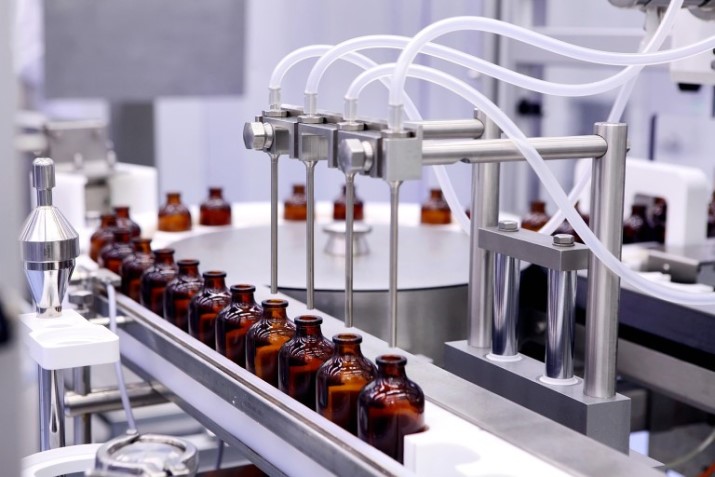 Row of vials on a conveyer belt.