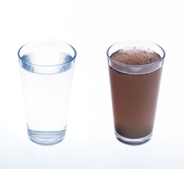 Glass of clean water next to a glass of unclean water.