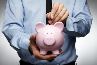 Person adding money to a piggy bank