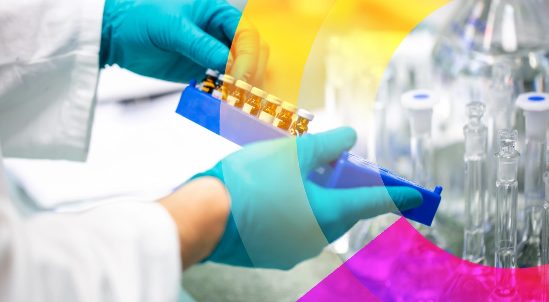 Gloved hands holding several vaccines in a row 