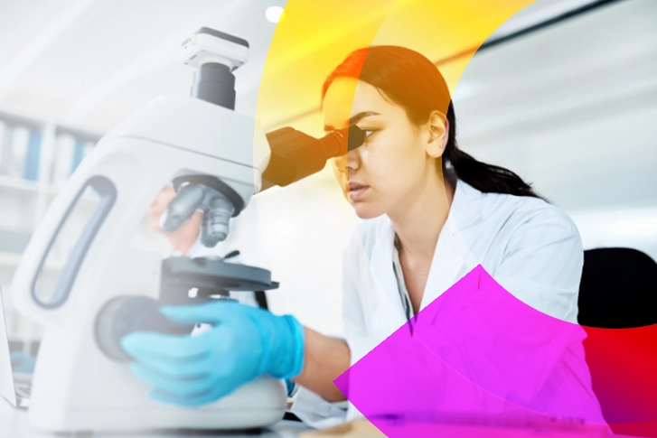 Woman looking into microscope in a laboratory. 