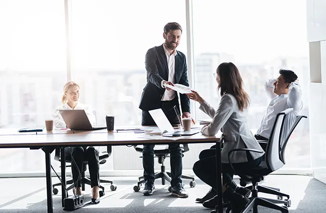 Business worker sharing papers around a conference table