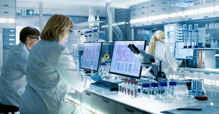 Lab technician looking at a computer monitor with in a labratory.