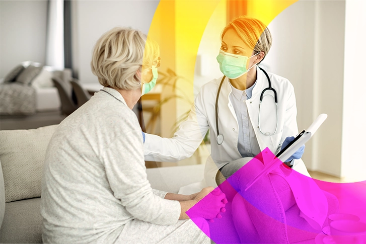 Nurse wearing a mask handing a patient a clipboard.